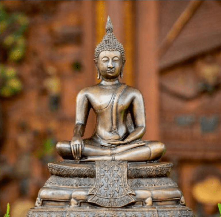 A golden Buddha statue in meditation pose with a blurred background.