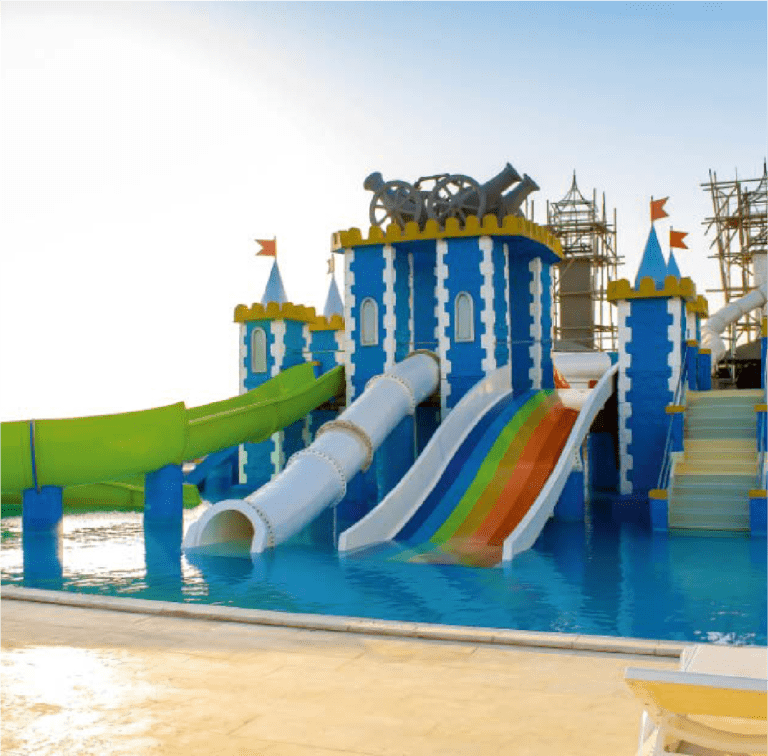 Colorful water park slides with a castle theme, under clear blue skies.